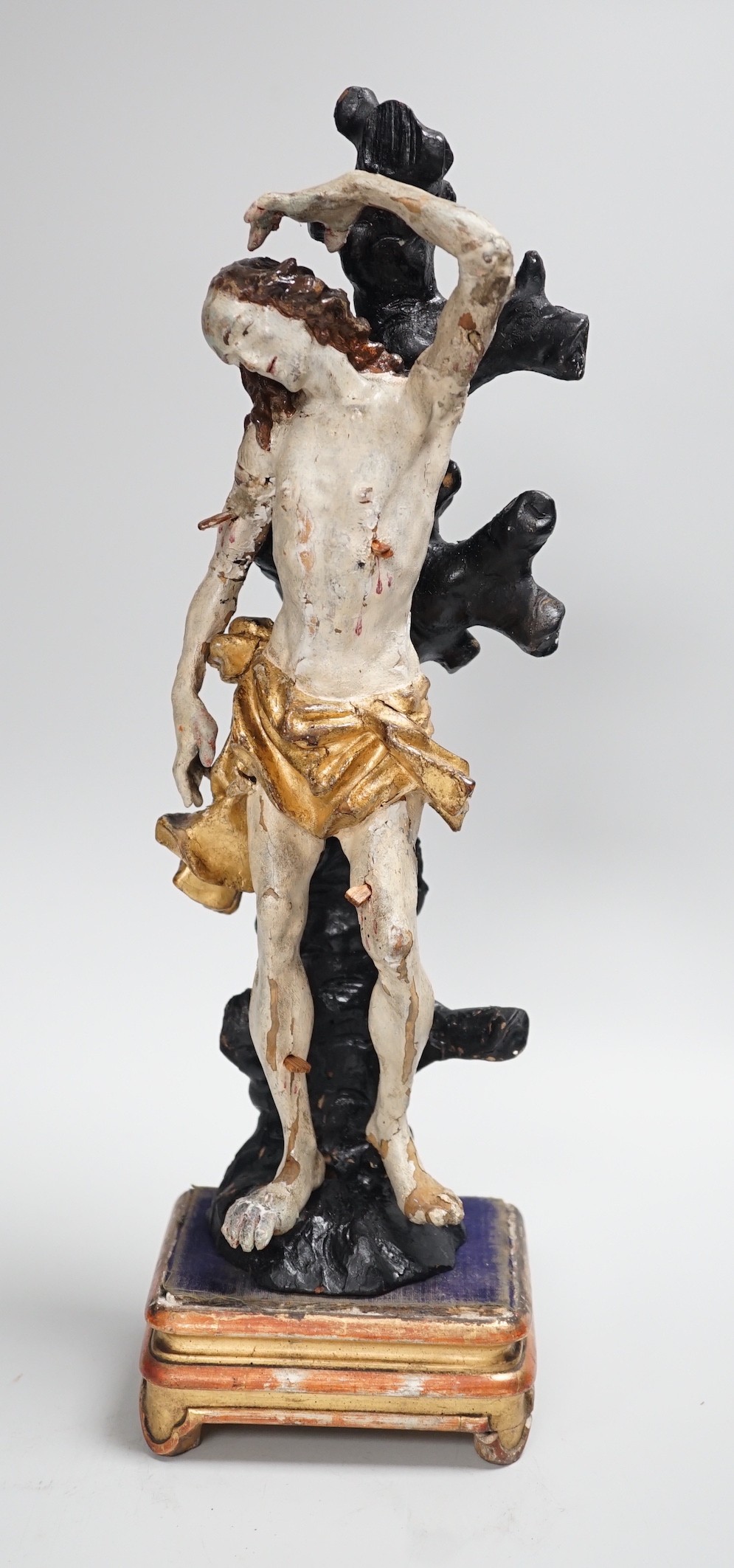 A 19th century Continental carved wooden polychrome figure of St. Sebastian on stand, total height 40cm